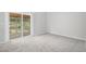 Carpeted bedroom featuring sliding glass doors leading to an outdoor patio area, providing ample natural light at 3246 S Nucla St, Aurora, CO 80013