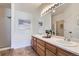 The main bathroom has a double vanity with wood cabinets, a soaking tub and glass-enclosed shower at 10311 Adams Pl, Thornton, CO 80229