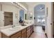 Bright double vanity bathroom featuring large mirrors, sinks, and plenty of cabinet space at 10311 Adams Pl, Thornton, CO 80229