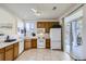 The bright kitchen has tile flooring, white appliances and overlooks the outdoor area through a sliding glass door at 10311 Adams Pl, Thornton, CO 80229