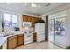 The kitchen has tile flooring, white appliances and a sliding glass door to the outdoor patio area at 10311 Adams Pl, Thornton, CO 80229