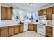 The bright kitchen overlooks the living room through an arch and has tile flooring and white appliances at 10311 Adams Pl, Thornton, CO 80229