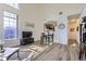 Inviting living area featuring wood floors, a high ceiling, and seamlessly connected dining space at 10311 Adams Pl, Thornton, CO 80229