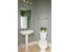 Cozy powder room with pedestal sink, mirror, toilet, and fresh green paint at 2800 Aurora Ave # 121, Boulder, CO 80303