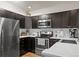 Well-equipped kitchen features stainless appliances, dark wood cabinets, and white countertops at 6848 Zenobia St # 9, Westminster, CO 80030