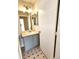 Well-lit half bath featuring a powder blue vanity, laminate floors, and light fixtures at 5151 Jasper St, Denver, CO 80239