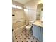 Well-lit bathroom featuring a tub shower, toilet, vanity, and eye-catching patterned flooring at 5151 Jasper St, Denver, CO 80239