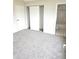 Bright bedroom features neutral carpeting, white trim, and a closet, with a full bathroom visible at 5151 Jasper St, Denver, CO 80239