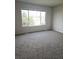 Bright bedroom features plush carpeting, a large window offering natural light, and neutral walls at 5151 Jasper St, Denver, CO 80239