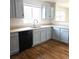 Kitchen with stainless steel sink, black dishwasher, light countertops and modern finishes at 5151 Jasper St, Denver, CO 80239