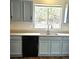 Kitchen featuring stainless steel sink, black dishwasher, and light blue cabinets at 5151 Jasper St, Denver, CO 80239