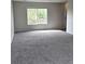 Large living room featuring neutral carpet and plenty of natural light from a large window at 5151 Jasper St, Denver, CO 80239