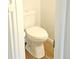A close-up of a standard white toilet with wood-look flooring in a well-lit bathroom at 5151 Jasper St, Denver, CO 80239