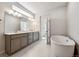 Bright bathroom with double vanity, soaking tub, and stylish lighting fixtures, and a window providing light at 1400 Colony Dr, Erie, CO 80026