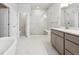 Well-lit bathroom with double vanity, glass-enclosed shower, and soaking tub, and linen closet at 1400 Colony Dr, Erie, CO 80026