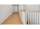 Well-lit hallway with wood floors and classic railing provides access to the upper level at 1400 Colony Dr, Erie, CO 80026