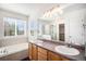 Bright bathroom with a double vanity, tub, and shower with tiled surround at 5479 Lost Meadow Trl, Castle Rock, CO 80104