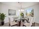 Bright dining room with modern glass table, six chairs, neutral carpet and a picture window at 5479 Lost Meadow Trl, Castle Rock, CO 80104