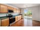 Bright kitchen with hardwood floors, stainless steel appliances, and a sliding door to the outdoor deck at 5479 Lost Meadow Trl, Castle Rock, CO 80104