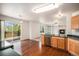 Open kitchen and dining area with wood floors, a breakfast bar, and a view to the deck at 5479 Lost Meadow Trl, Castle Rock, CO 80104