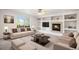 Comfortable living room with fireplace, custom built-ins, and a large window at 5479 Lost Meadow Trl, Castle Rock, CO 80104