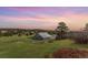 Rural barn set on a grassy field with a colorful sunset sky at 19855 Draco Dr, Monument, CO 80132