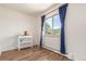 Sun-lit bedroom with wood-look floors, large window with curtains, and a bright, neutral color palette at 19855 Draco Dr, Monument, CO 80132