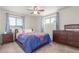 Comfortable bedroom with plush carpeting, two windows with decorative curtains, and a matching dresser set at 19855 Draco Dr, Monument, CO 80132