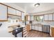 Bright kitchen features white cabinets and modern appliances at 19855 Draco Dr, Monument, CO 80132