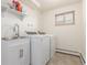 Functional laundry room with modern washer and dryer, a sink with vanity, and tiled flooring at 19855 Draco Dr, Monument, CO 80132
