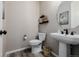Powder bathroom featuring a round mirror, floating shelves, modern fixtures, and a pedestal sink with decor at 3059 Morningbird Ln, Castle Rock, CO 80109