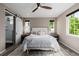 Comfortable bedroom featuring a ceiling fan, a sliding barn door to the bathroom, and natural light from the windows at 3059 Morningbird Ln, Castle Rock, CO 80109