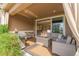 This covered patio is furnished with a fire pit, grill, and comfortable seating for relaxing outdoors at 3059 Morningbird Ln, Castle Rock, CO 80109