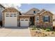 Charming home with a two-car garage, stone accents, and well-maintained landscaping at 3059 Morningbird Ln, Castle Rock, CO 80109
