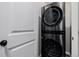 New stackable washer and dryer appliances next to a white door, offering convenience and space-saving design at 3059 Morningbird Ln, Castle Rock, CO 80109