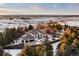 Stunning aerial view of a luxury home surrounded by lush greenery and snow covered fields in a serene setting at 7883 Fox Creek Trl, Franktown, CO 80116
