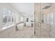 Luxurious bathroom features a soaking tub, glass shower and marble tiling at 7883 Fox Creek Trl, Franktown, CO 80116