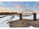 Inviting entrance to the property featuring an ornate gate with brick pillars and a tranquil landscape at 7883 Fox Creek Trl, Franktown, CO 80116