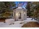 Gazebo featuring a decorative design surrounded by mature pine trees and snow-covered ground at 7883 Fox Creek Trl, Franktown, CO 80116