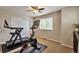Bedroom featuring home gym with stationary bike, treadmill, and a window at 7472 S Memphis St, Aurora, CO 80016