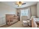 Neutral toned Bedroom with crib, chair with ottoman, and a bookshelf by the window at 7472 S Memphis St, Aurora, CO 80016