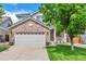 Charming two-story home featuring a brick facade, a two-car garage, and a well-manicured front yard at 7472 S Memphis St, Aurora, CO 80016