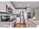 Modern kitchen with stainless steel appliances, granite countertops, and white cabinetry at 7472 S Memphis St, Aurora, CO 80016