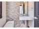 Modern bathroom featuring tile walls, a floating sink, and a sleek toilet at 7837 Inverness Blvd, Englewood, CO 80112