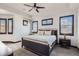 Bedroom with tray ceiling, fan, accent wall, and three windows with dark frames at 7837 Inverness Blvd, Englewood, CO 80112