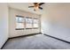 Empty bedroom featuring three windows and neutral carpet at 7837 Inverness Blvd, Englewood, CO 80112