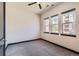 Bright bedroom with neutral carpet, three large windows, and dark trim at 7837 Inverness Blvd, Englewood, CO 80112