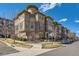 Attractive four-story townhome exterior with a turret, brick accents, and manicured landscaping at 7837 Inverness Blvd, Englewood, CO 80112