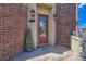 Charming brick entryway with a decorative glass front door and classic sconce lighting at 7837 Inverness Blvd, Englewood, CO 80112