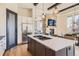 Open kitchen with a large island, stainless steel refrigerator and view of the fireplace at 7837 Inverness Blvd, Englewood, CO 80112